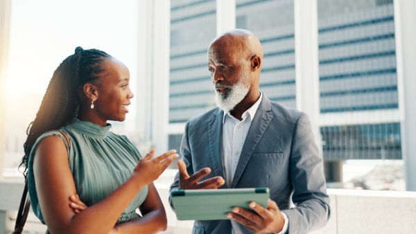 Two people chatting about their findings on a tablet