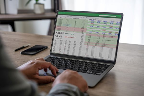 A laptop showing spreadsheets in a meeting