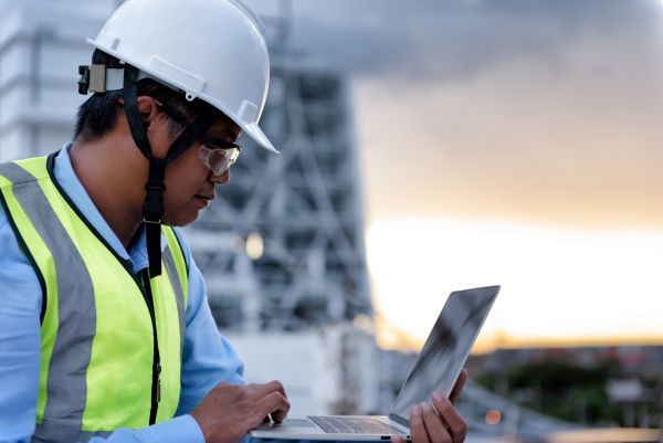 A construction worker using a laptop
