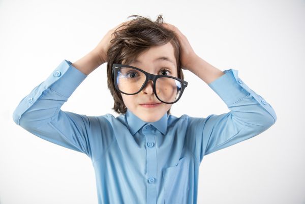 Boy with large, crooked glasses looking disheveled 